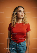 Young woman with curly hair in casual outfit on orange background