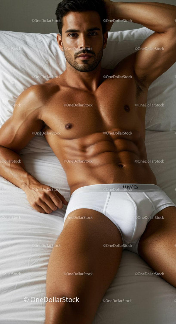 Relaxed muscular man lying on bed in white underwear