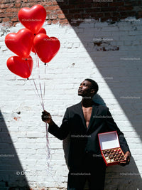 Man Holding Heart Balloons and Chocolate Gift Box