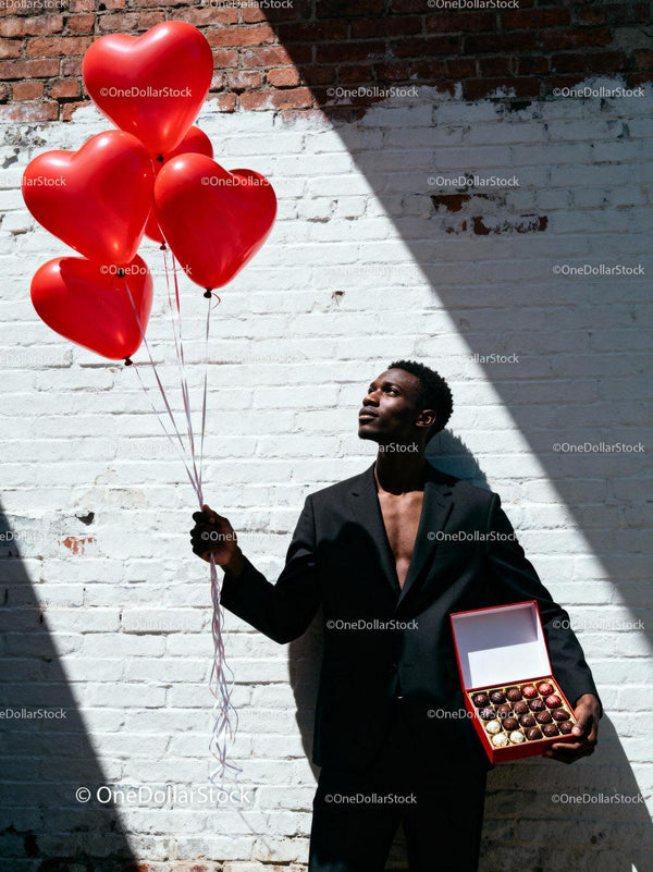 Man Holding Heart Balloons and Chocolate Gift Box