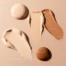Assorted liquid foundation shades on beige background