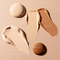 Assorted liquid foundation shades on beige background