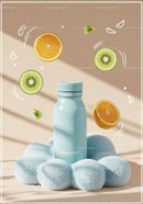 Minimalistic bottle amidst fresh fruit slices and soft clouds