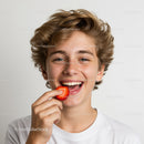 Young boy enjoying fresh strawberries with a big smile in a joyful portrait