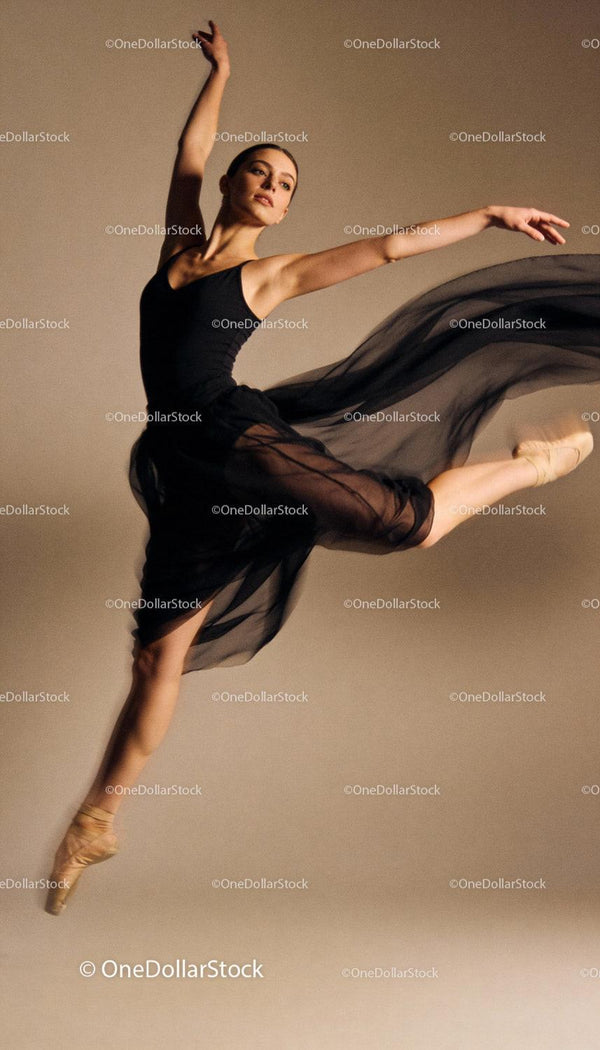 Graceful ballet dancer leaping mid-air in black dress