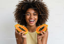 Smiling Black Woman Holding Fresh Halved Papayas for Healthy Lifestyle