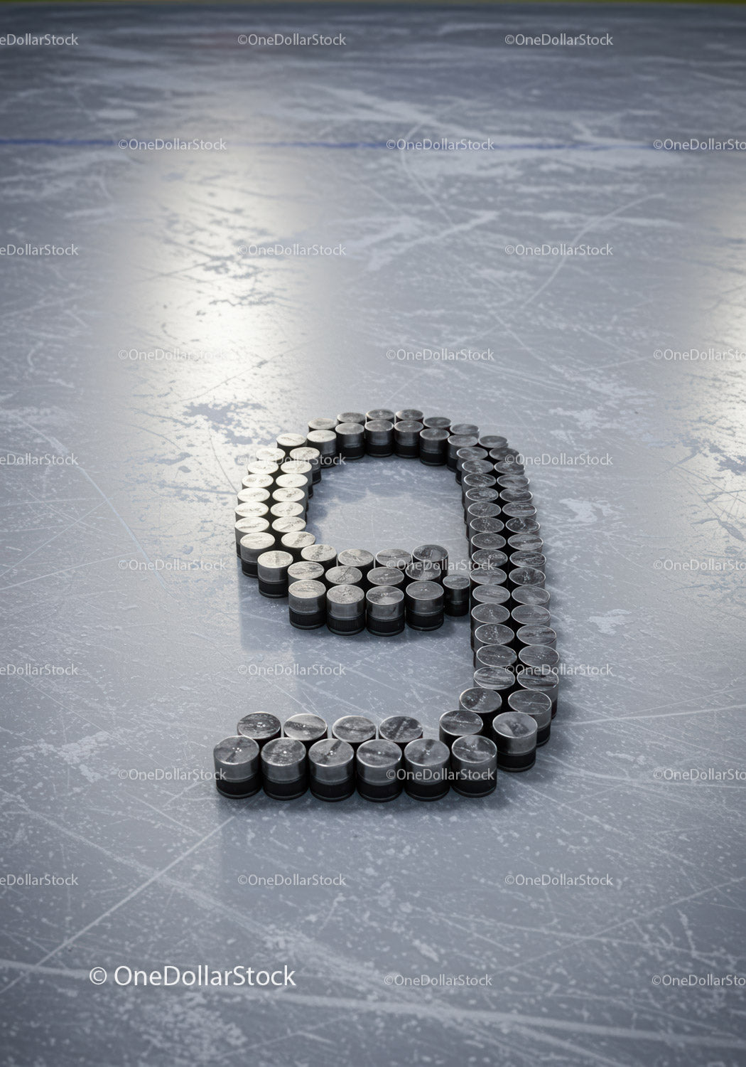 Number Nine Composed of Hockey Pucks on Icy Surface