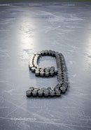 Number Nine Composed of Hockey Pucks on Icy Surface