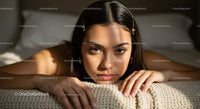 Intimate Portrait of a Young Woman Resting on a Cozy Bed