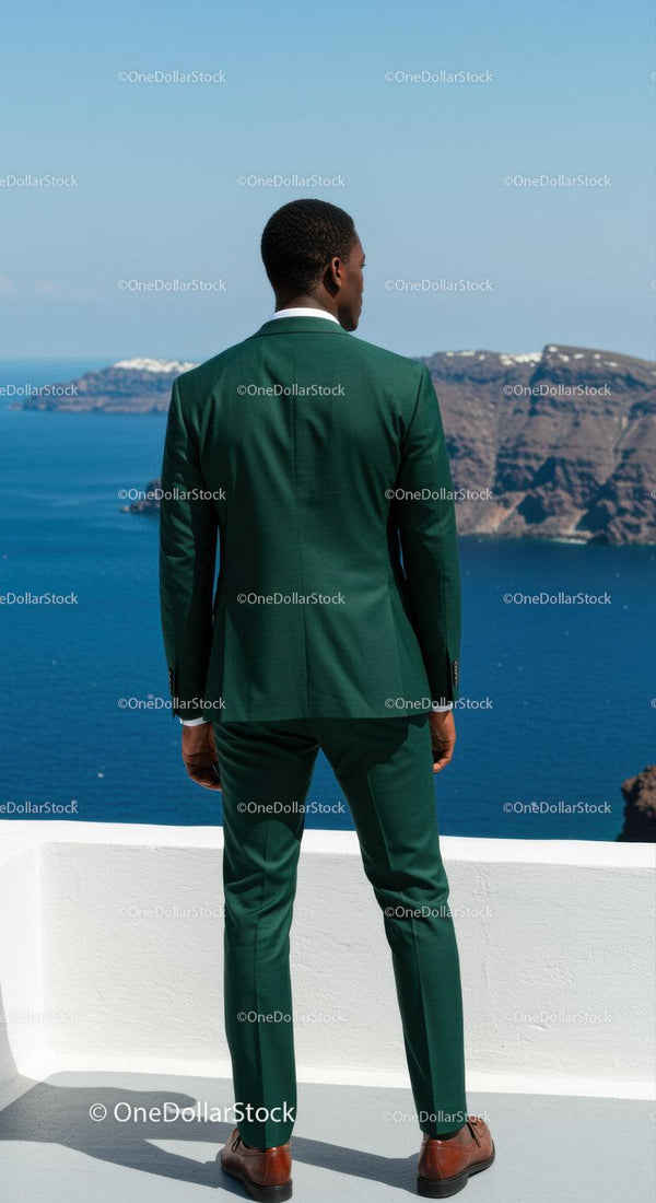 Man in Green Suit Overlooking Calm Blue Sea and Cliffs
