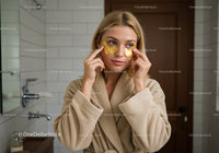 Young Woman Applying Eye Patches for Skincare Routine in Bathroom