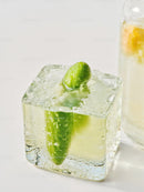 Fresh cucumber frozen inside a clear ice cube