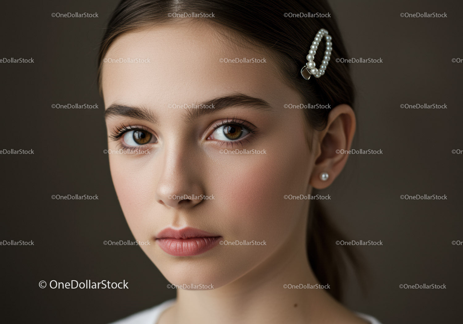 Elegancka młoda kobieta z perłową spinką do włosów i brązowymi oczami