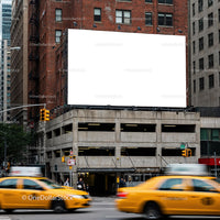 Empty billboard above urban parking garage with passing taxis