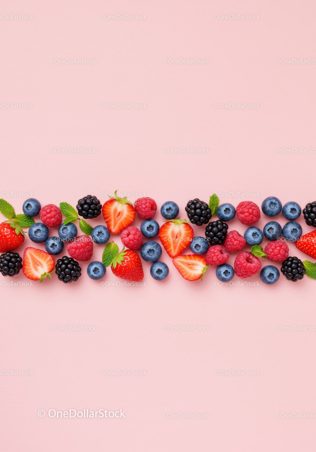 Fresh mixed berries with mint on pastel pink background