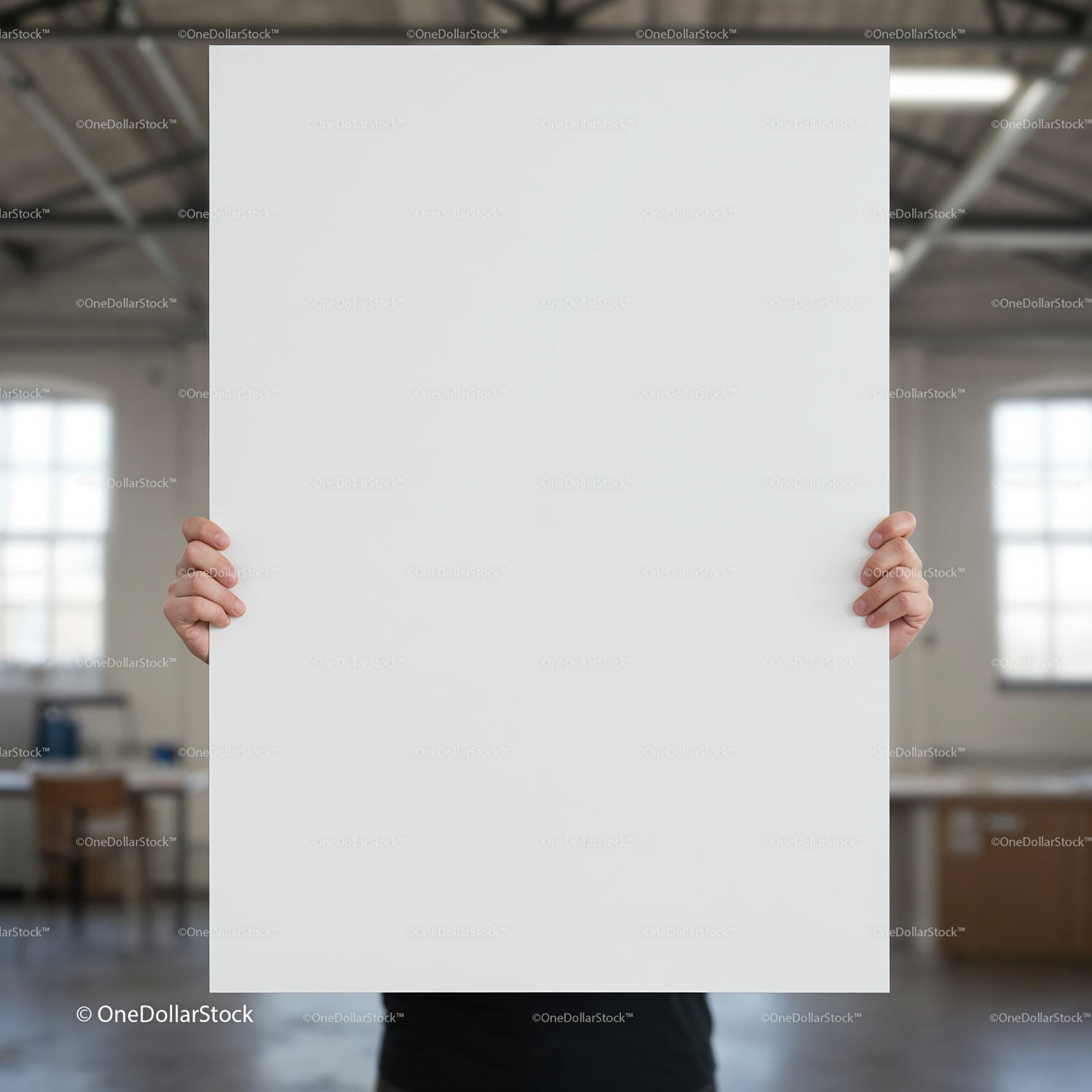 Person Holding Large Blank White Poster in Industrial Space