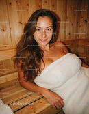 Young Woman Relaxing in Warm Wooden Sauna With Smile