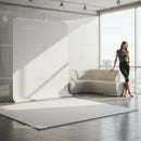 Woman leaning on sofa in bright modern room with backdrop