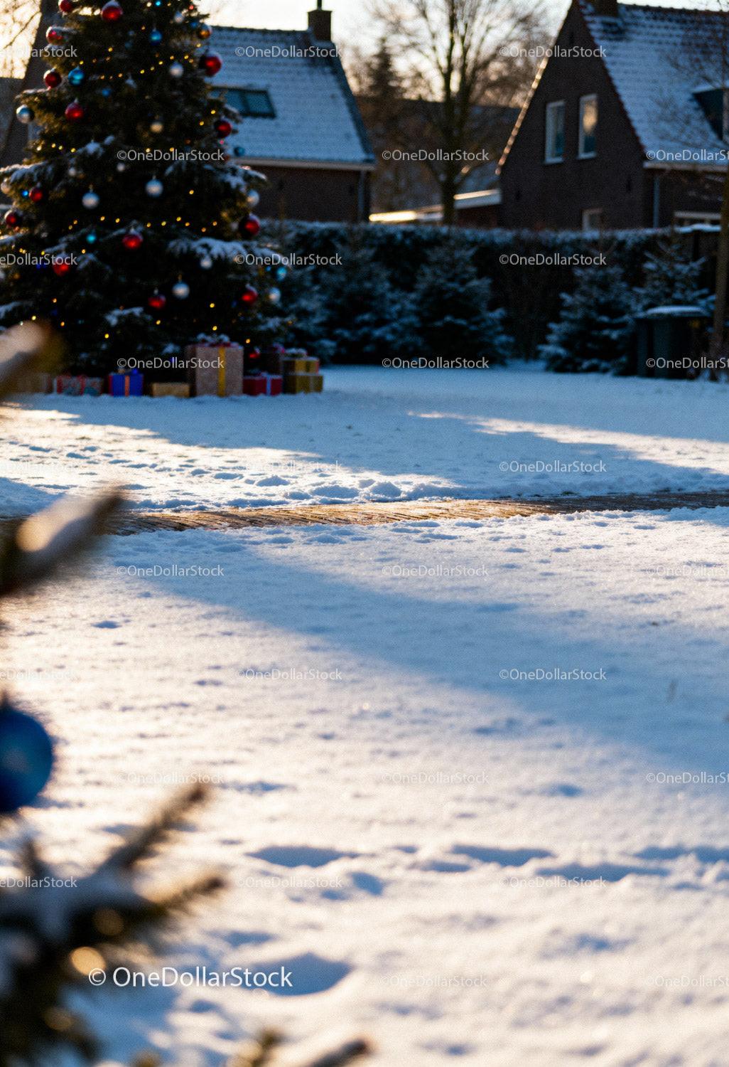 Snowy outdoor scene with decorated Christmas tree and gifts