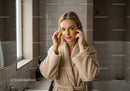 Young Woman in Bathrobe Applying Gold Eye Patches in Spa Atmosphere