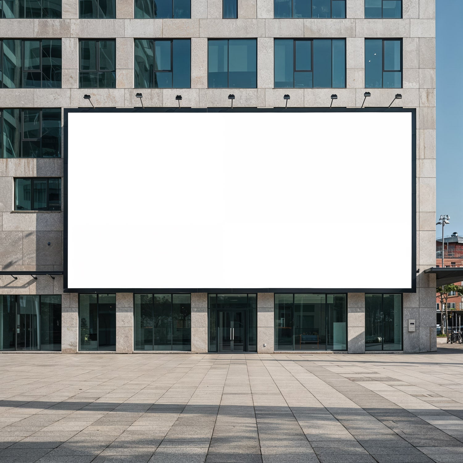 Duży, pusty billboard na fasadzie nowoczesnego budynku biurowego