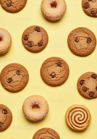 Assorted cookies and donuts on yellow background