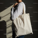 Person carrying plain eco friendly tote bag on shoulder