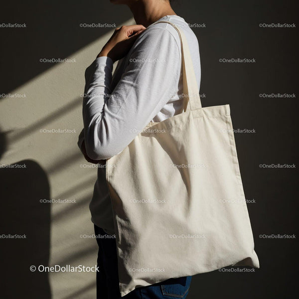 Person carrying plain eco friendly tote bag on shoulder JPG Mockup Image