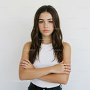 Young Woman with Long Brown Hair in White Top Crossed Arms Portrait