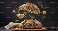 Rustic sourdough bread torn with scattered rosemary leaves
