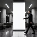 Blurred businessman walking past large blank urban billboard