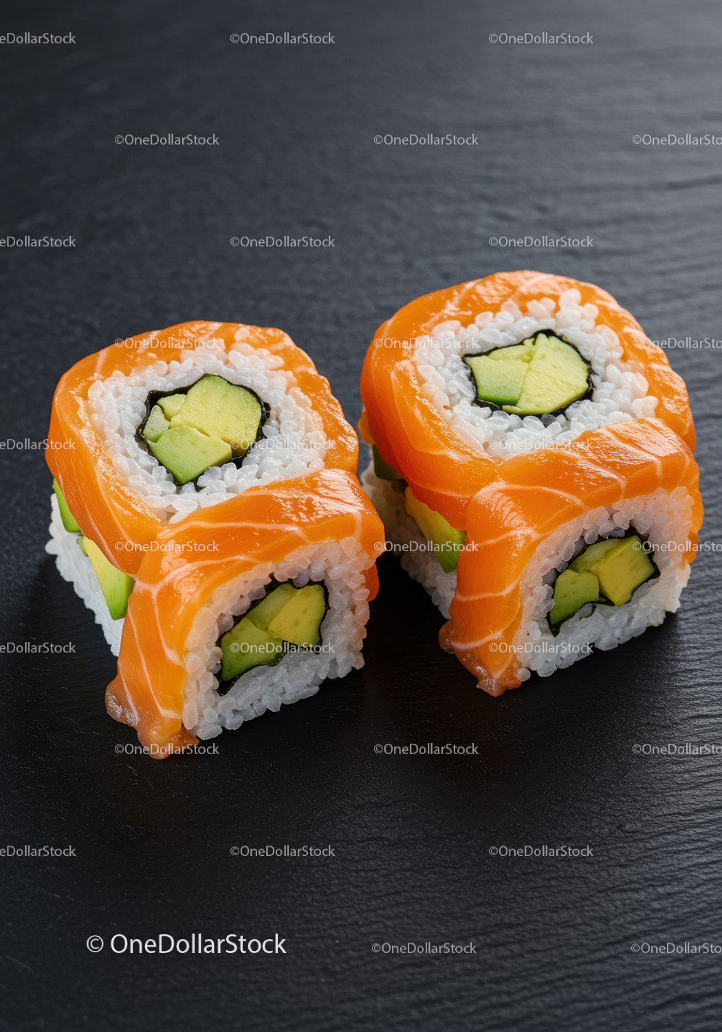 Świeże rolki sushi z łososiem i awokado na ciemnym łupku