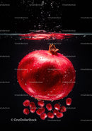 Fresh pomegranate submerged with scattered seeds underwater
