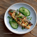 Grilled Sardine with Cucumber Slices and Fresh Herbs on White Plate