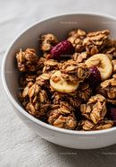 Crunchy granola with banana slices and berries in bowl