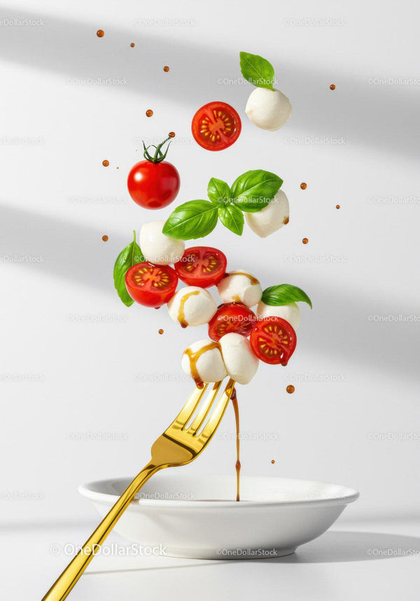 Fork with flying caprese salad ingredients and balsamic drizzle