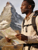 Male hiker studying map near mountain peak