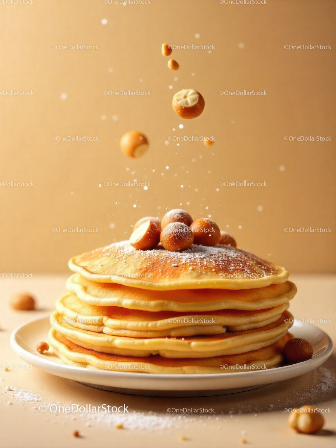 Stack of fluffy pancakes topped with hazelnuts and powdered sugar