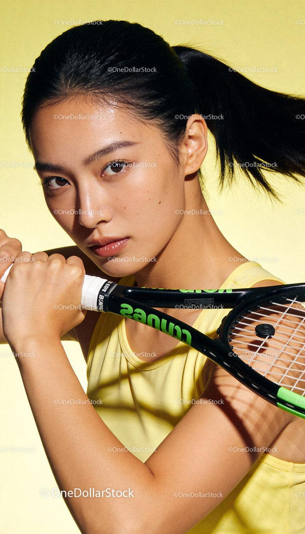 Focused young female tennis player with racket in hand