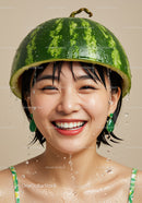 Joyful woman wearing watermelon hat with water droplets