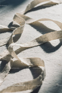 Close-up of White Plastic Ribbon Waste on Sandy Beach