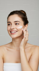 Beautiful Woman Applying Skincare Cream on Cheek for Radiant Skin