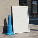 Empty White Frame and Blue Traffic Cone on Sidewalk