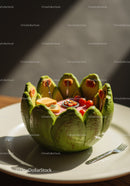 Miniature picnic scene inside a carved green fruit bowl