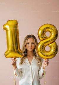 Young woman holding golden 18 balloons on pink background