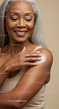 Elegant Senior Woman Smiling While Applying Lotion to Flawless Skin