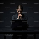 Thoughtful Woman at Laptop in Dark Modern Workspace