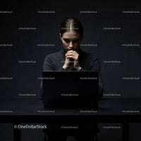 Thoughtful Woman at Laptop in Dark Modern Workspace