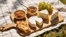 Assorted Cheeses and Fresh Snacks on Wooden Board