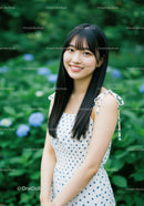Young Woman in Polka Dot Summer Dress in Lush Garden